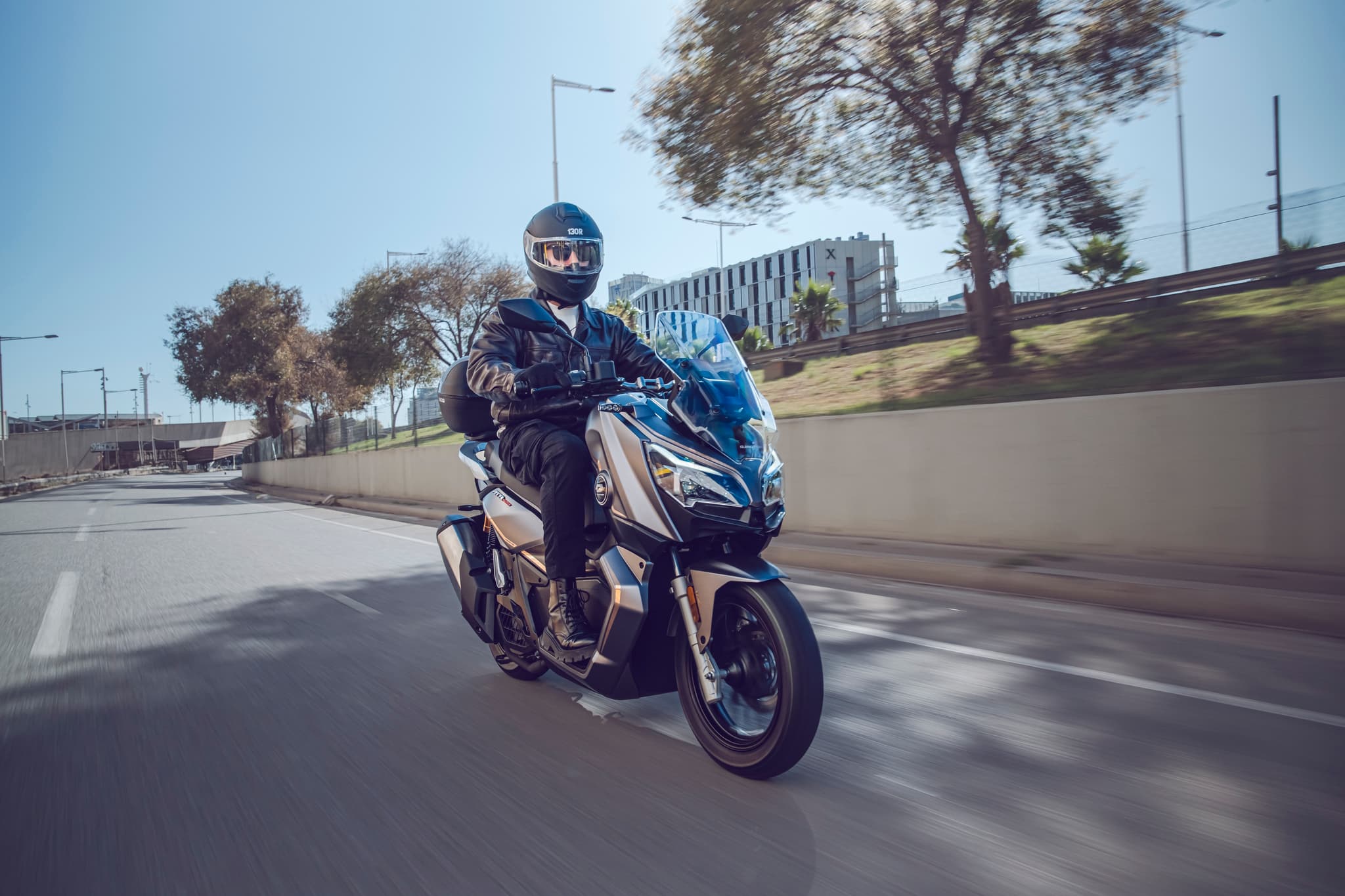 Motorista rodando en scooter por una ronda urbana