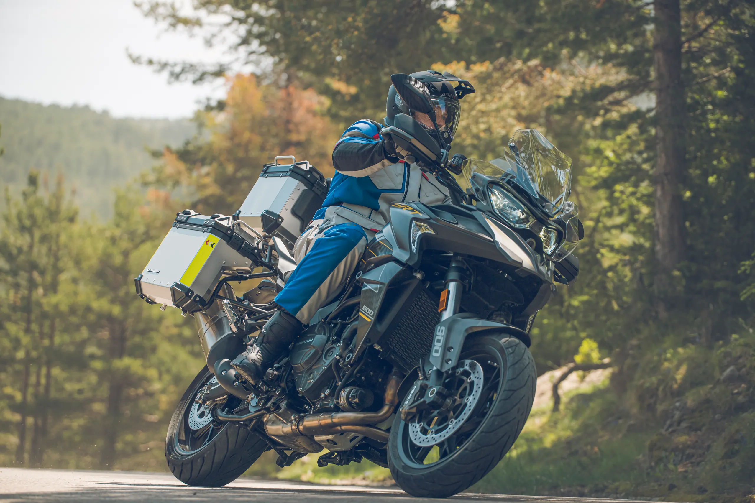 Motorista inclinando una trail cargada con maletas en una carretera de montaña